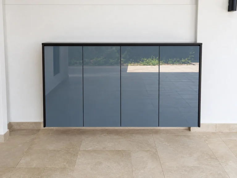 Blue-Grey Four-Door Shoe Cabinet With A Glossy Finish And Dark Frame.