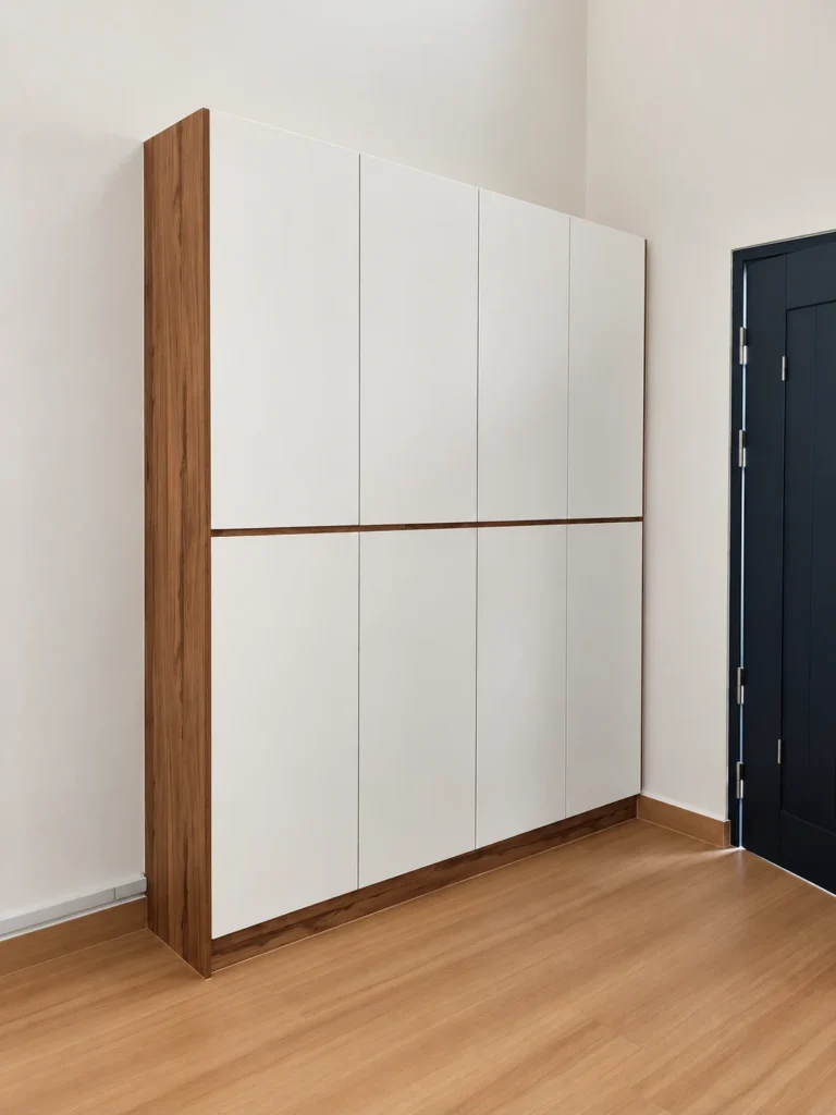 White Shoe Cabinet With A Vertical Wood Accent And Central Horizontal Wood Strip.