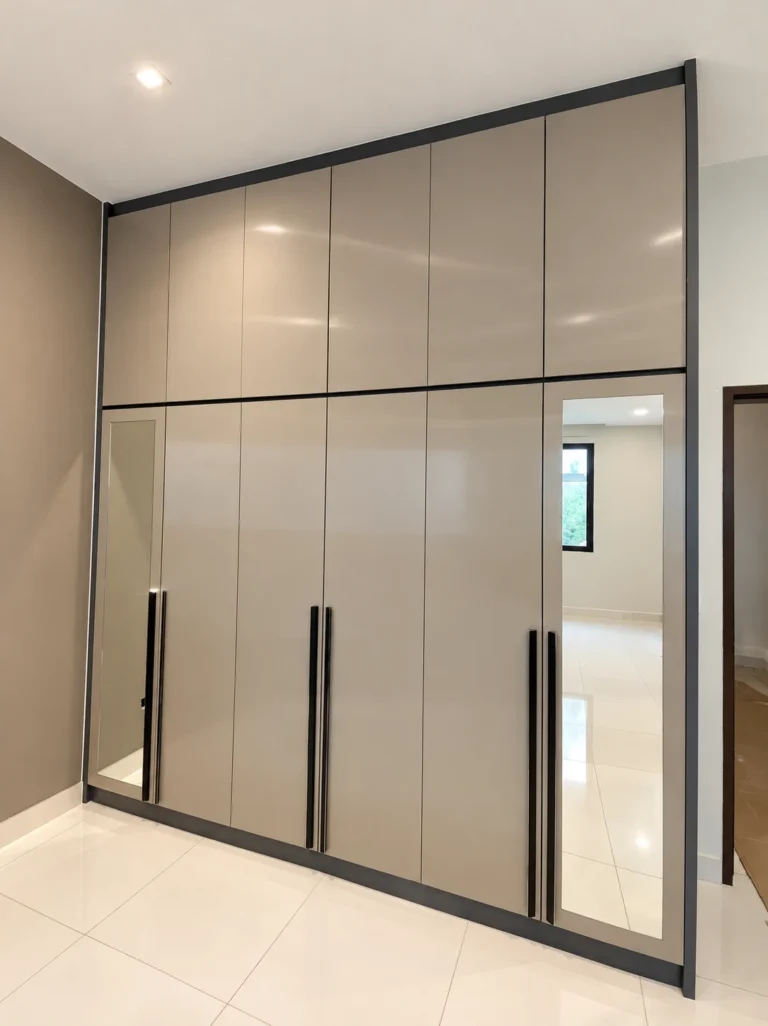 Glossy Taupe Built-In Wardrobe With Long Black Handles And Mirrored Panels.