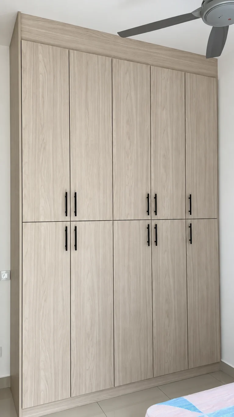 Pale Woodgrain Wardrobe With Black Handles And Upper And Lower Doors.
