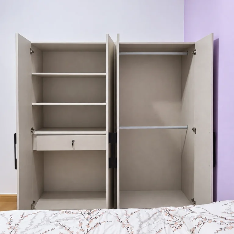 Open Light Grey Wardrobe Showing Shelves, Drawer And Hanging Rails.